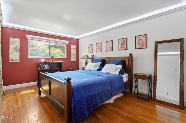 bedroom with wood-type flooring and crown molding