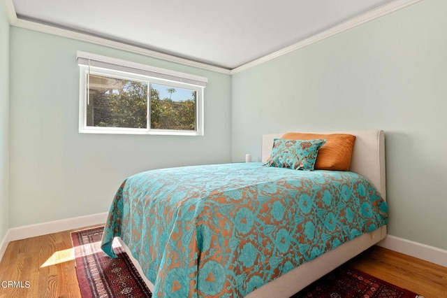 bedroom with crown molding and wood-type flooring