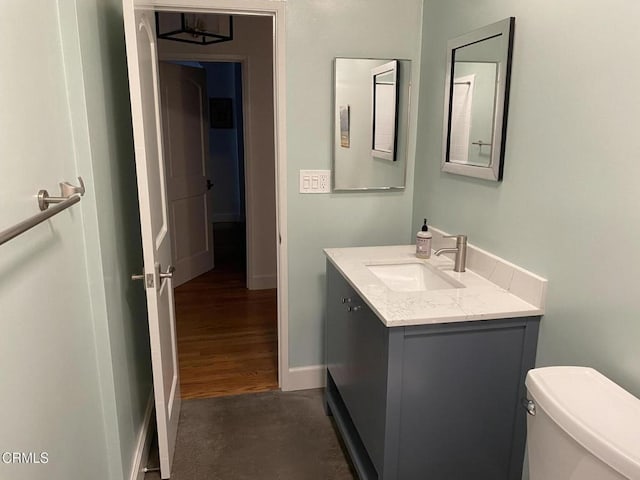 bathroom with vanity, hardwood / wood-style flooring, and toilet