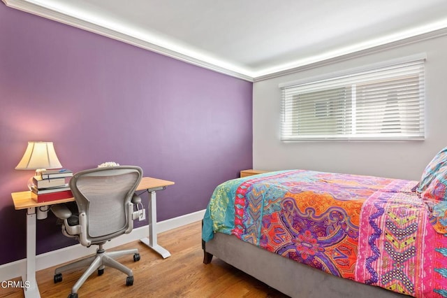 bedroom with hardwood / wood-style flooring and ornamental molding