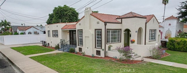 mediterranean / spanish-style house with a front yard