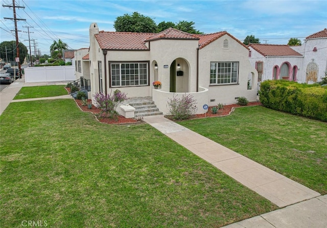 mediterranean / spanish house with a front yard