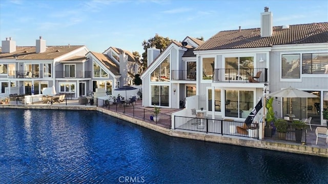 rear view of property with a patio area and a water view