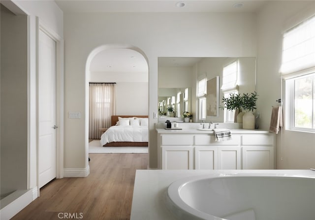 bathroom with vanity, a bath, and hardwood / wood-style floors