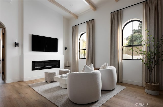 living room featuring beam ceiling and light wood-type flooring