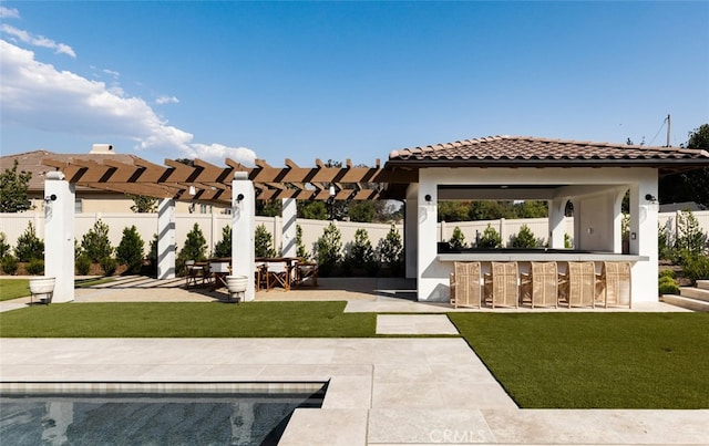 rear view of property with a patio, a pergola, a bar, and a yard