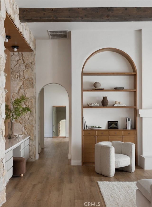 hallway with beamed ceiling and hardwood / wood-style floors