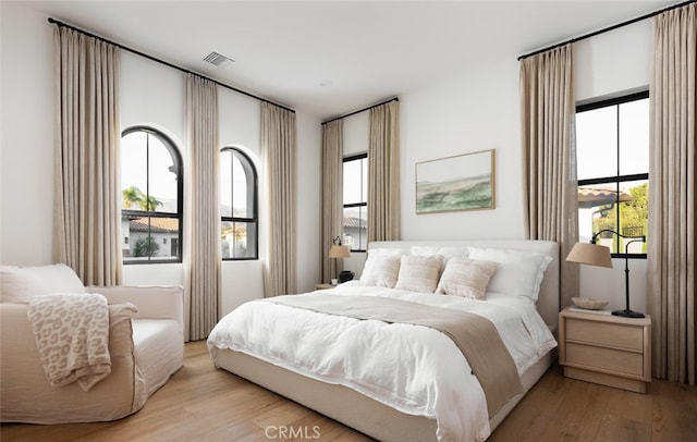 bedroom with light hardwood / wood-style flooring and multiple windows