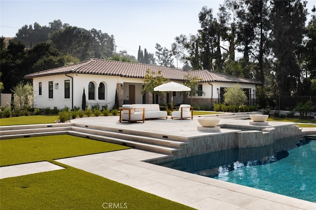 rear view of house featuring a patio, a lawn, and an outdoor hangout area