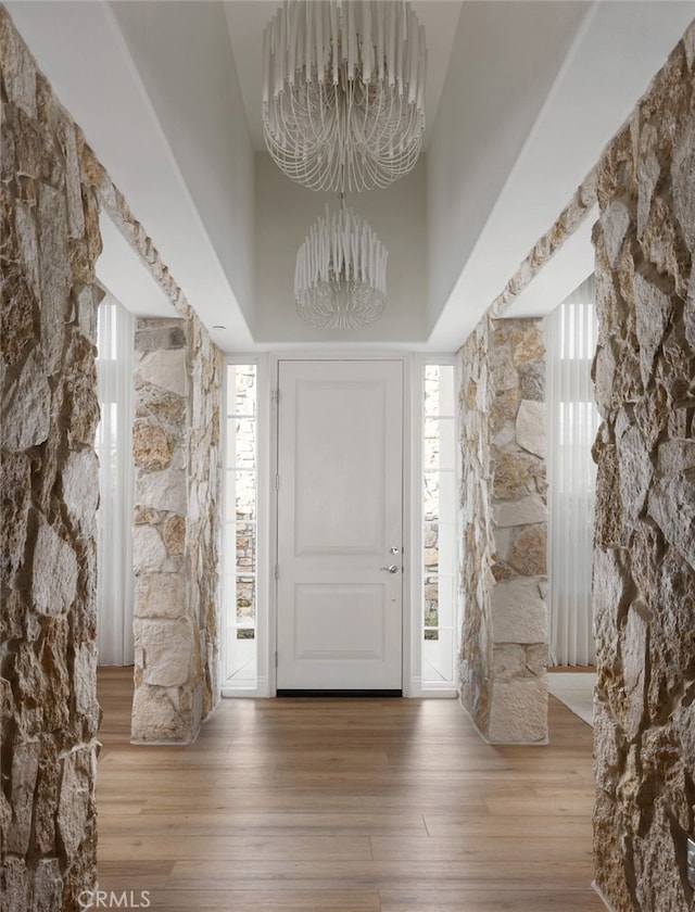 foyer entrance featuring a towering ceiling, hardwood / wood-style floors, and a wealth of natural light