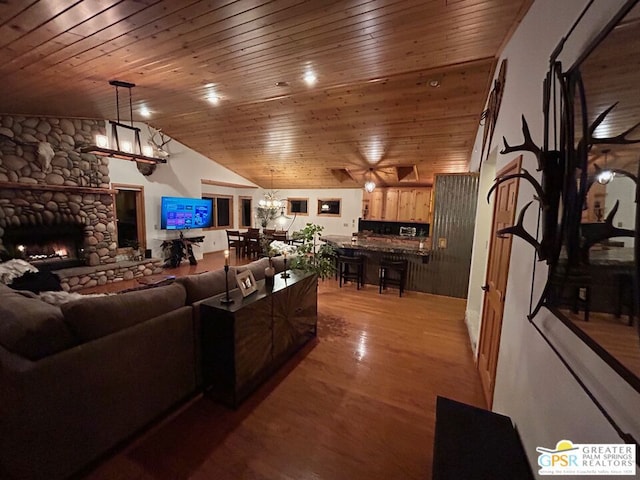 living room featuring lofted ceiling, hardwood / wood-style floors, wood ceiling, and a fireplace