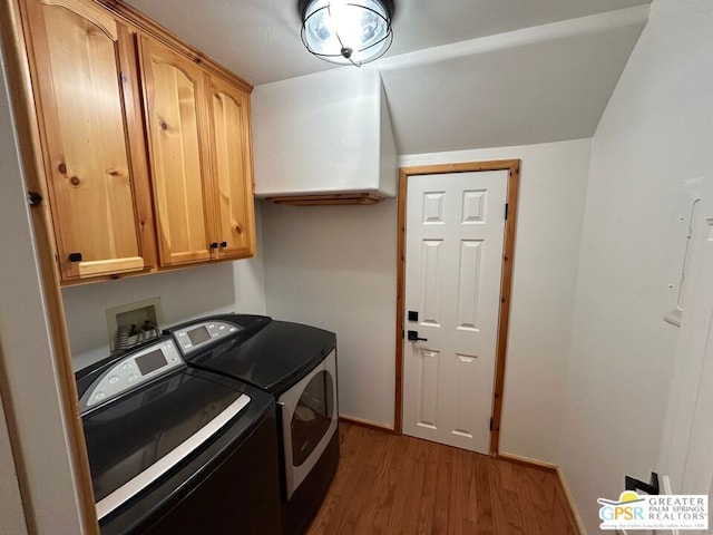 laundry area featuring washing machine and dryer, dark hardwood / wood-style floors, and cabinets