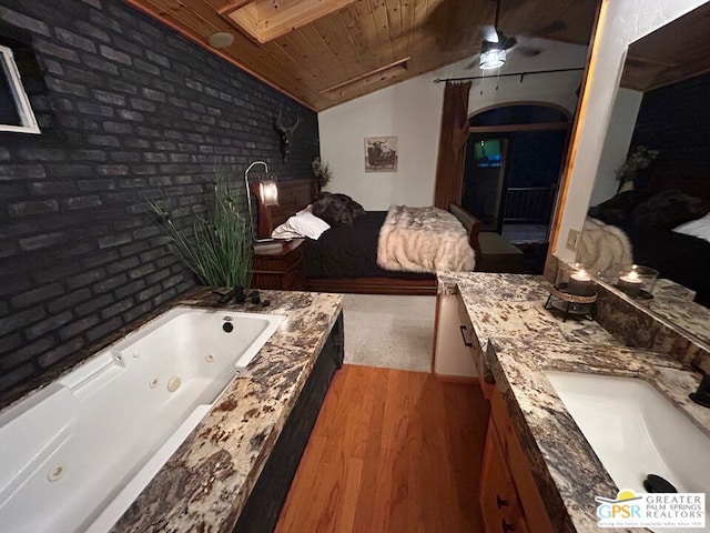 bathroom with a bathing tub, hardwood / wood-style flooring, wooden ceiling, vaulted ceiling with skylight, and vanity