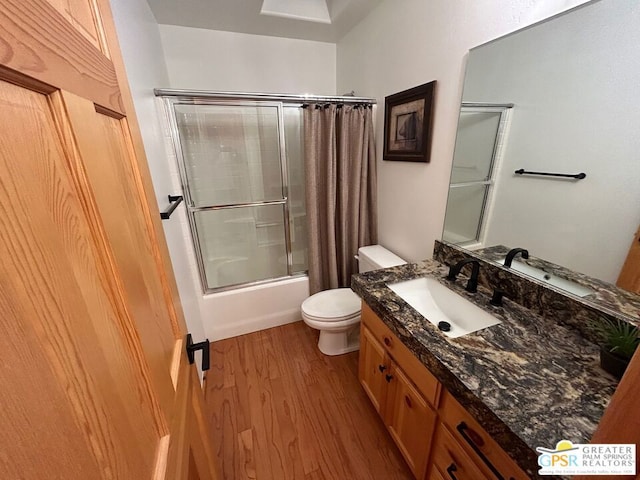 full bathroom featuring vanity, toilet, wood-type flooring, and shower / tub combo with curtain