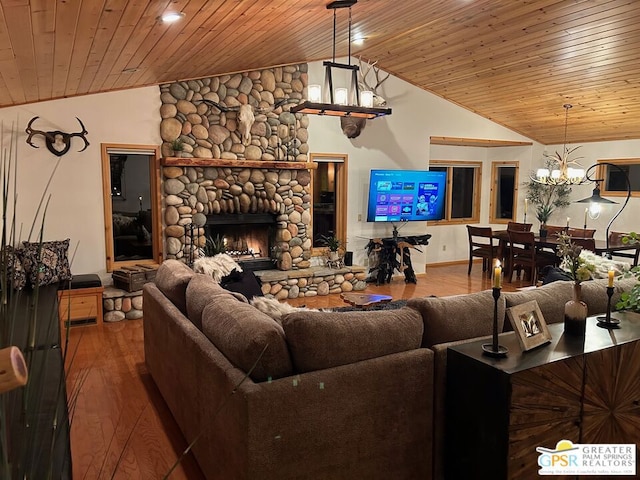 living room featuring wood ceiling, hardwood / wood-style floors, vaulted ceiling, a fireplace, and a notable chandelier