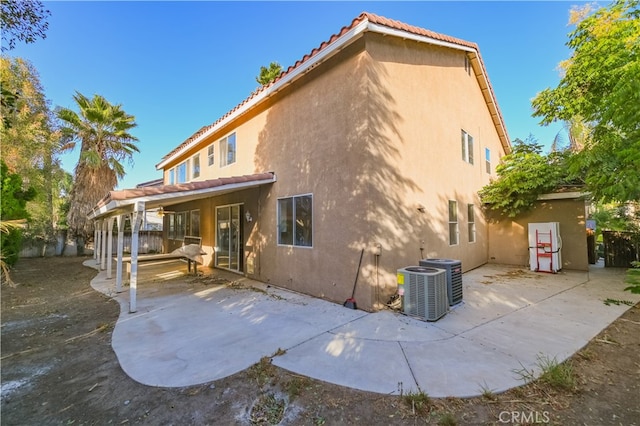 back of property with cooling unit and a patio