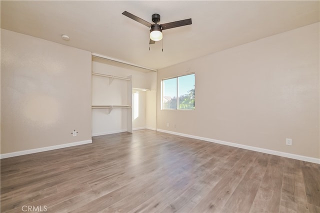 unfurnished bedroom with wood-type flooring, a closet, and ceiling fan