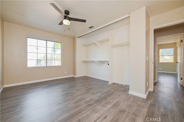 unfurnished bedroom with hardwood / wood-style floors, a closet, and ceiling fan