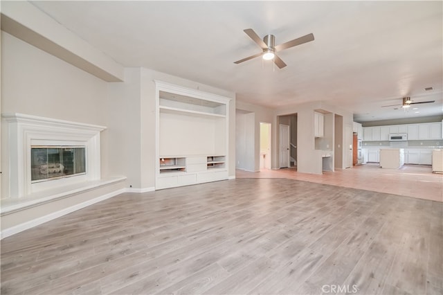 unfurnished living room with ceiling fan and light hardwood / wood-style flooring