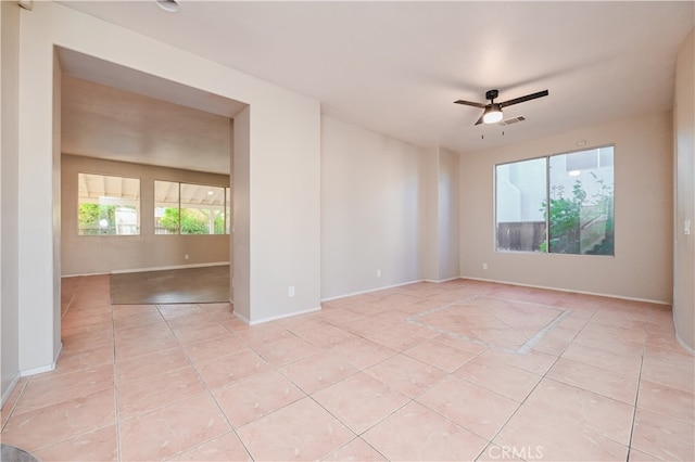 unfurnished room with light tile patterned floors and ceiling fan