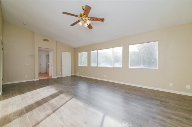 empty room featuring lofted ceiling, wood-type flooring, and ceiling fan