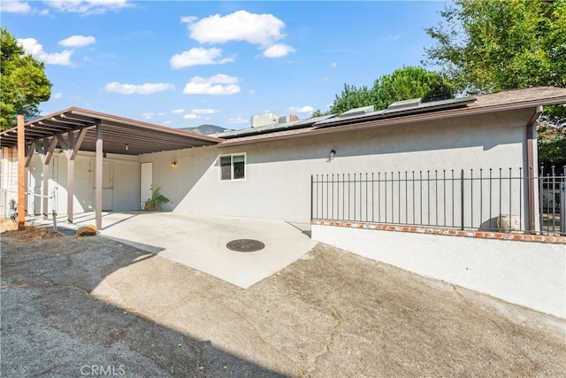 rear view of property featuring solar panels