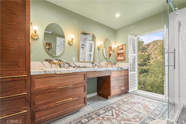 bathroom with tile patterned flooring, vanity, and walk in shower