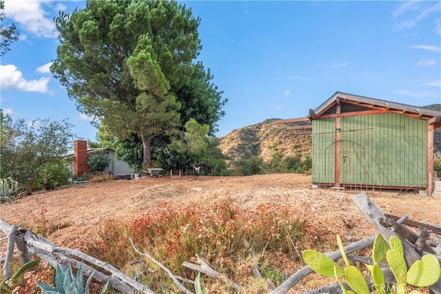 view of yard with a mountain view and an outbuilding