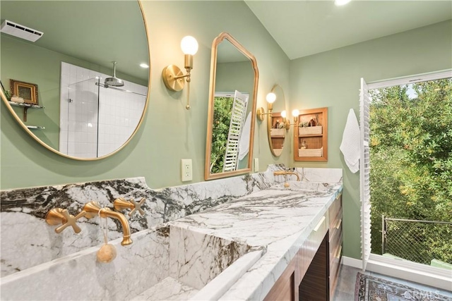 bathroom featuring a shower and vanity