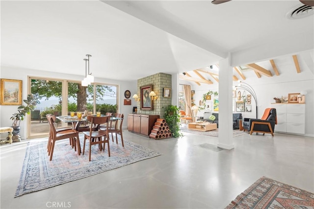 dining room with concrete floors and lofted ceiling with beams