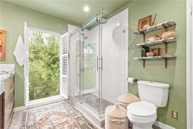 bathroom with tile patterned floors, vanity, toilet, and walk in shower