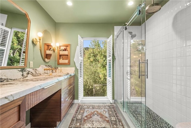 bathroom with vanity and a shower with door