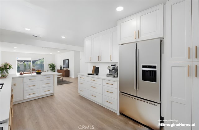 kitchen with stainless steel fridge with ice dispenser, light hardwood / wood-style flooring, and white cabinetry