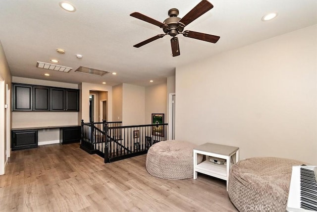 living area with ceiling fan and light wood-type flooring