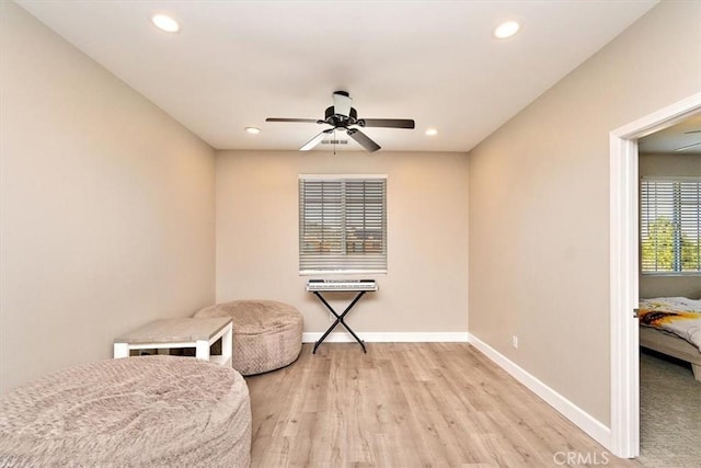 living area with light wood-type flooring and ceiling fan