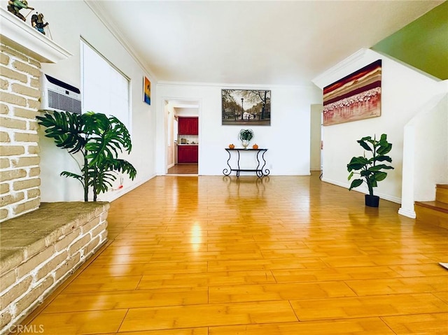 interior space with hardwood / wood-style floors, a wall mounted AC, and crown molding