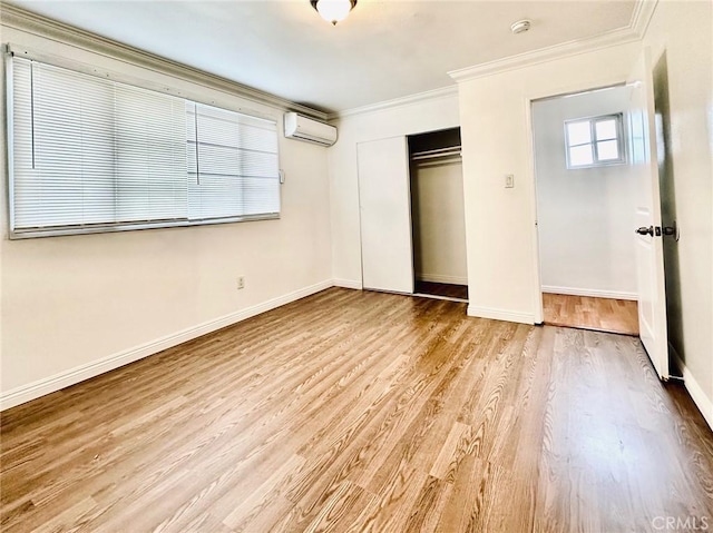 unfurnished bedroom featuring light hardwood / wood-style floors, a wall unit AC, a closet, and crown molding