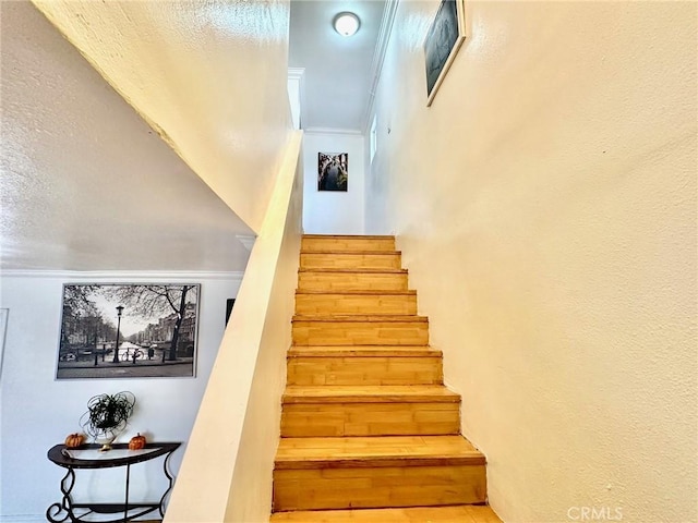 stairway featuring ornamental molding