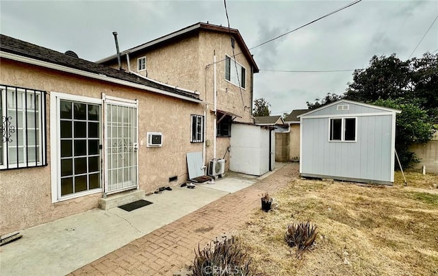 back of property with a patio and a shed