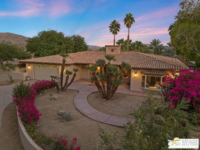 mediterranean / spanish home with a patio area, a mountain view, and a garage