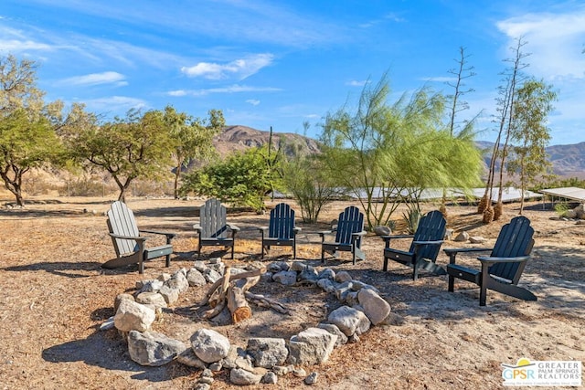 view of yard with a mountain view and an outdoor fire pit