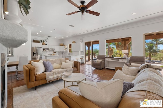 living room featuring ceiling fan, light tile patterned flooring, and ornamental molding