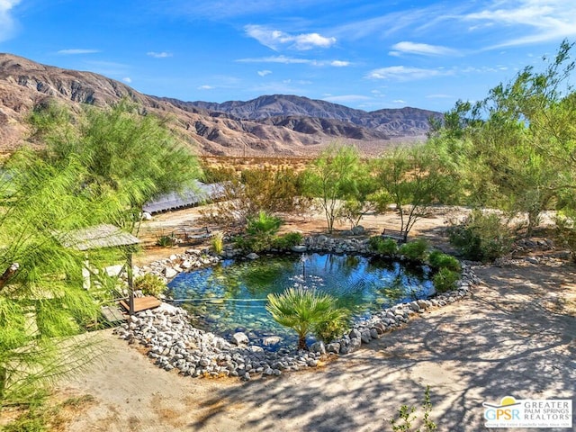 view of swimming pool featuring a water and mountain view