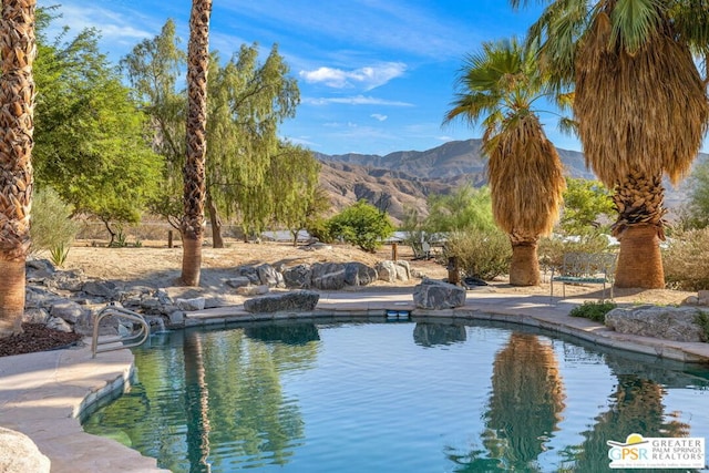 view of swimming pool with a mountain view