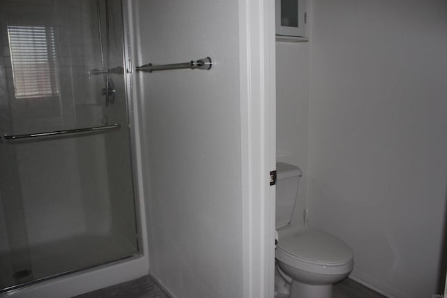 bathroom with an enclosed shower and toilet