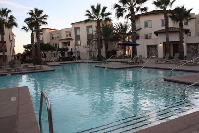 pool at dusk with a patio area