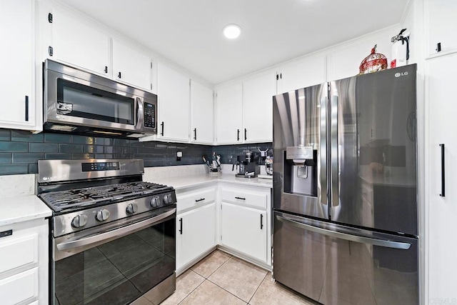 kitchen featuring white cabinets, backsplash, stainless steel appliances, and light tile patterned flooring