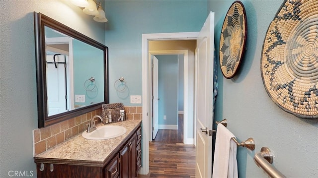 bathroom featuring vanity, wood-type flooring, and backsplash