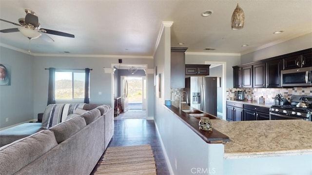 kitchen with backsplash, ceiling fan, stainless steel appliances, dark brown cabinetry, and ornamental molding