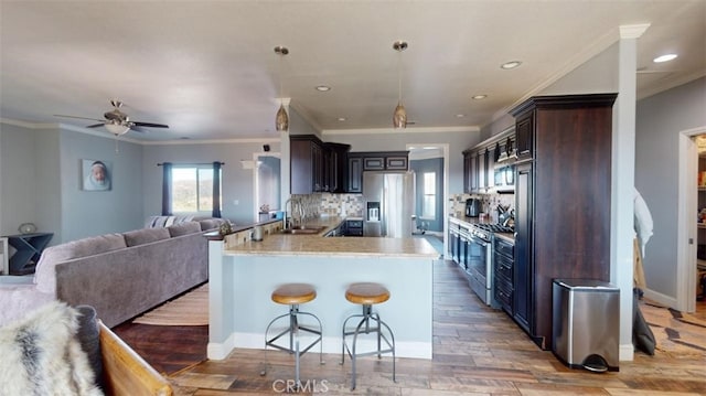 kitchen with kitchen peninsula, light hardwood / wood-style flooring, sink, crown molding, and stainless steel appliances